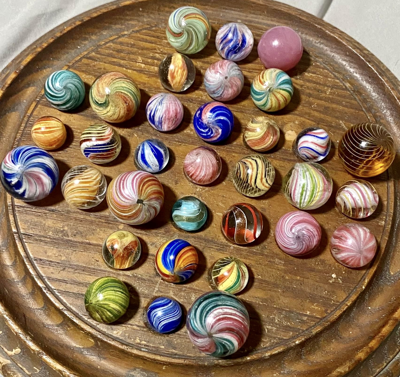 A real collection of antique German handmade glass marbles with colorful internal swirls