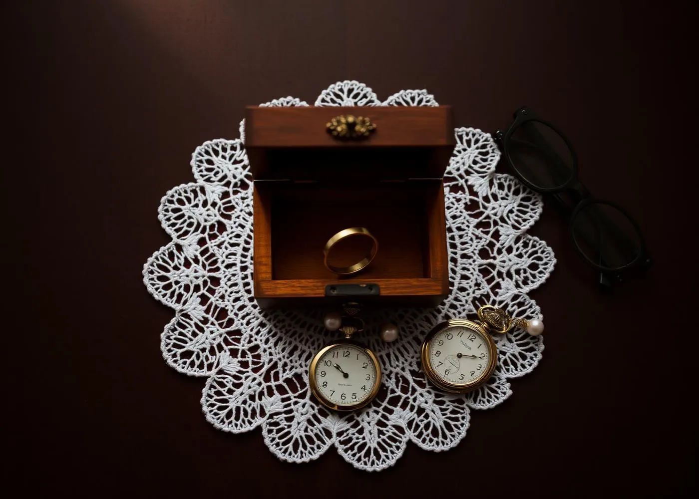 Wooden jewelry box with watches and rings on a lace doily