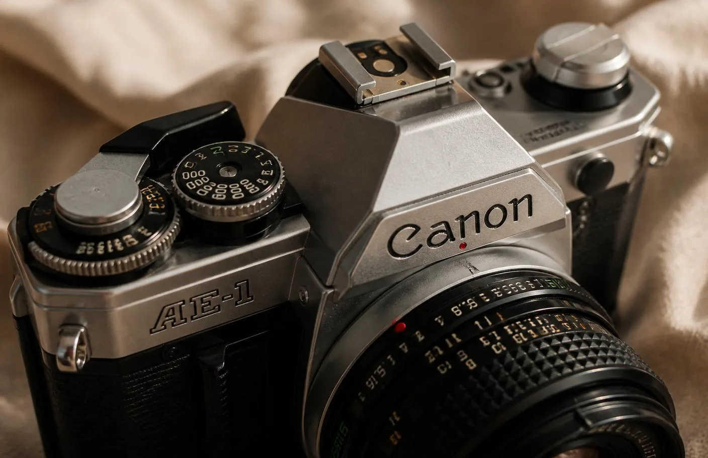 Detail of a chrome Canon AE-1 top plate with the film advance lever and shutter dial
