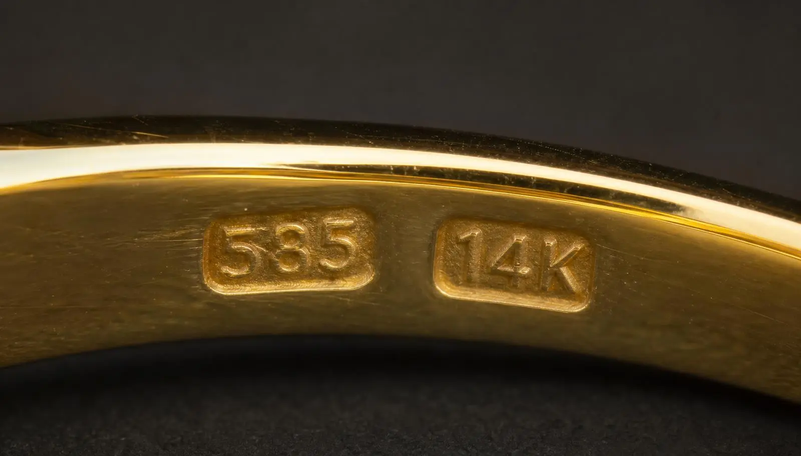 Extreme macro of the inside of a gold ring band stamped 585 and 14K