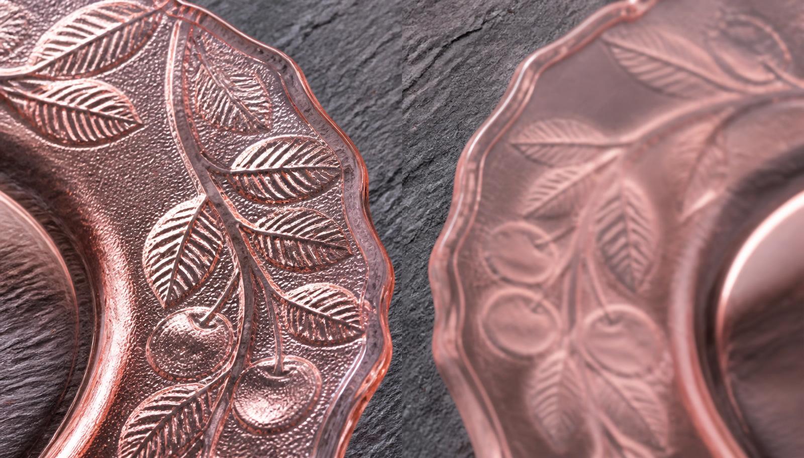 Macro comparison of two pink pressed glass plate rims, one with crisp sharply molded cherry leaves and fine veining, the other soft and blurry with shallow muddy detail