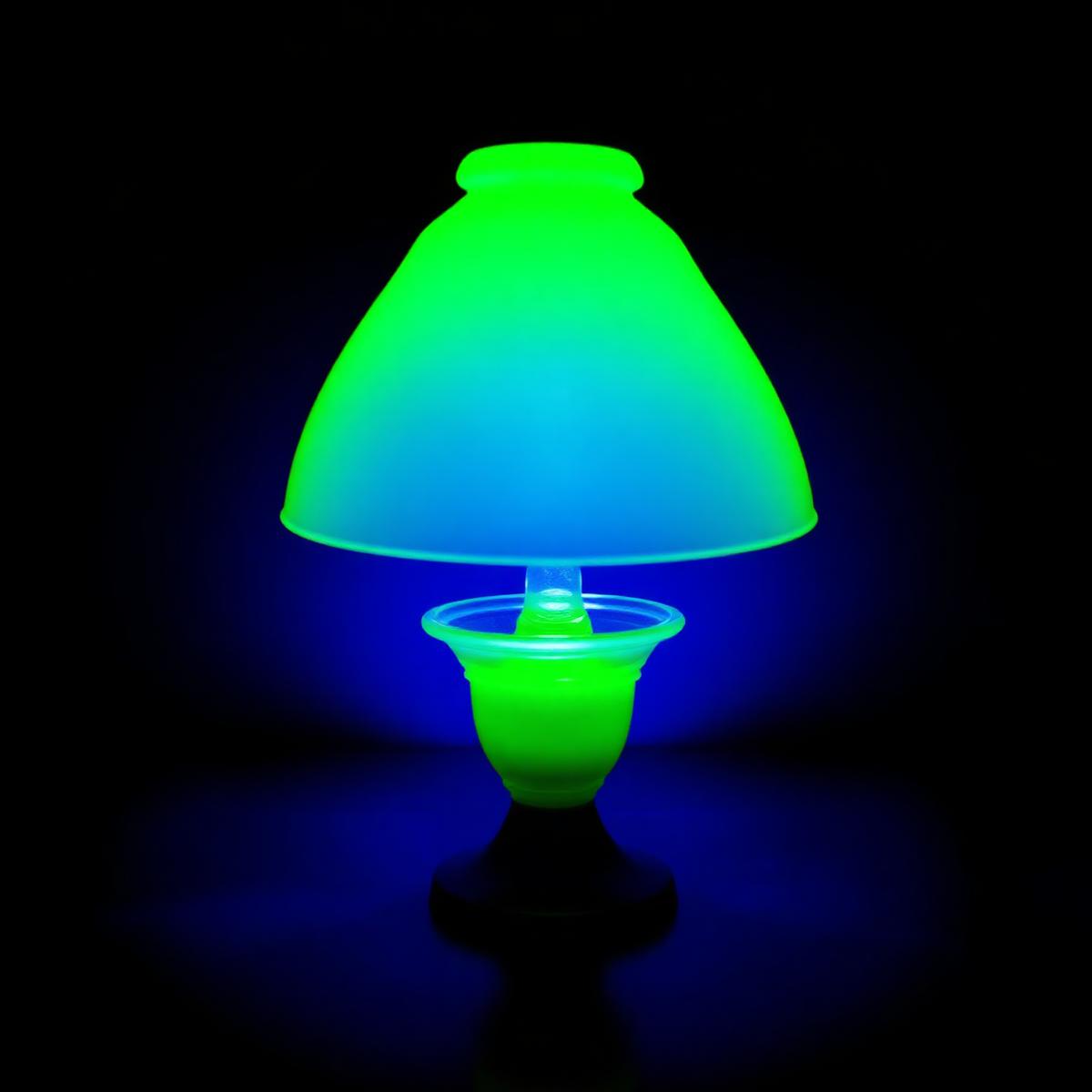 A Vaseline glass (uranium) fairy lamp glowing brilliant fluorescent green under UV blacklight