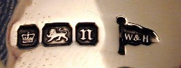 A British four-mark set: town mark on the left, lion passant, date letter "n," and the maker's mark "W&H" (Walker & Hall) on the right.