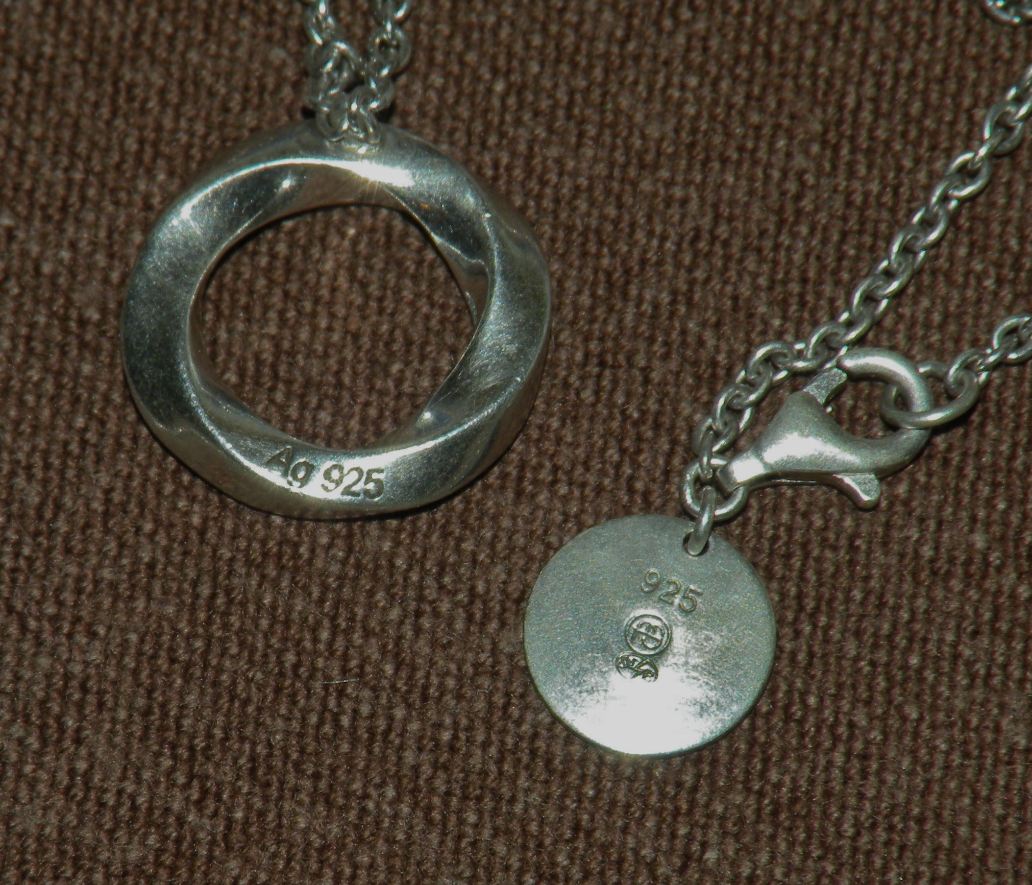 Two pieces of modern jewelry stamped with "Ag 925" and "925" — the universal numeric mark for sterling silver.