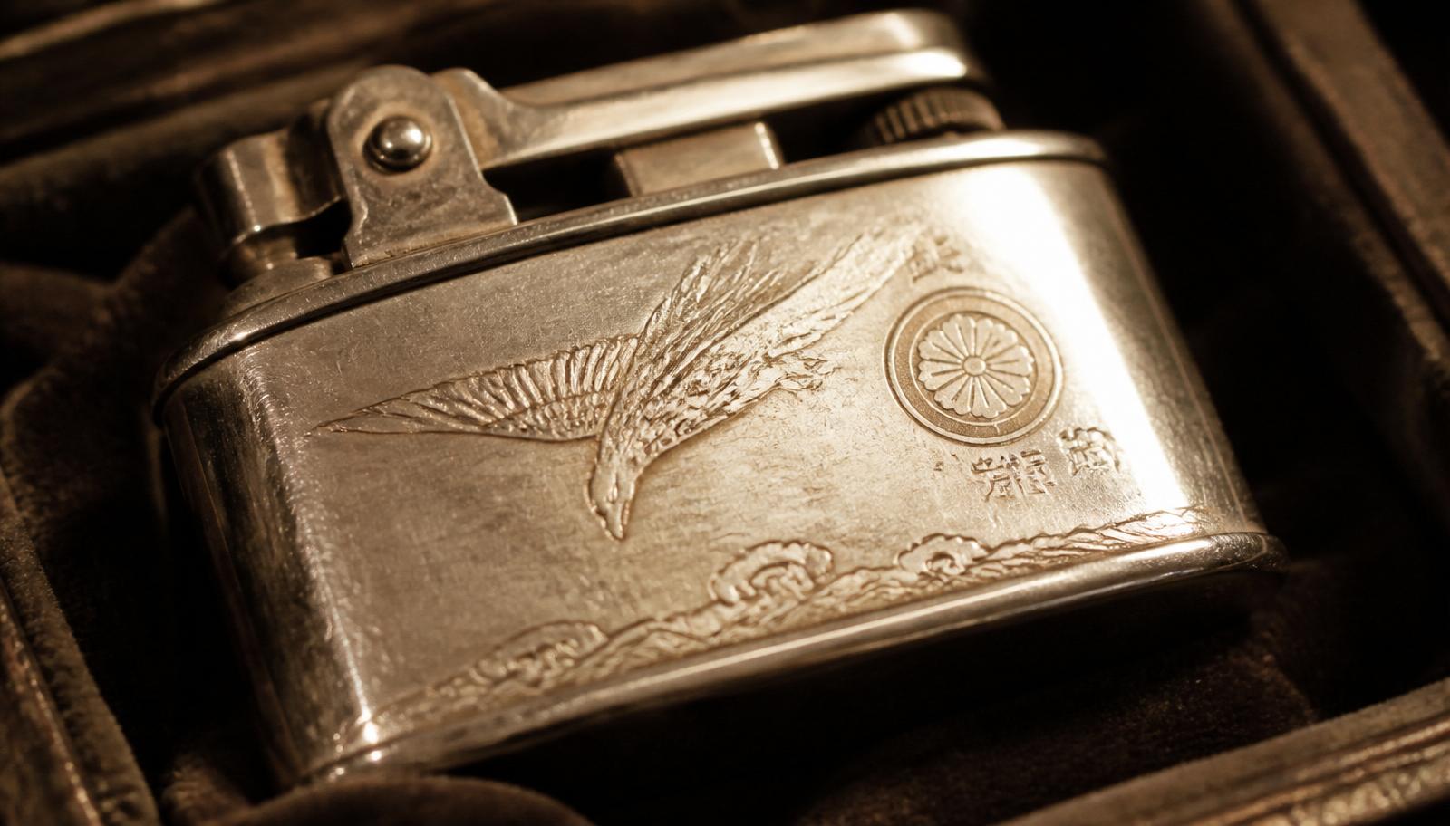 A vintage chrome Japanese souvenir lighter with an engraved crane motif